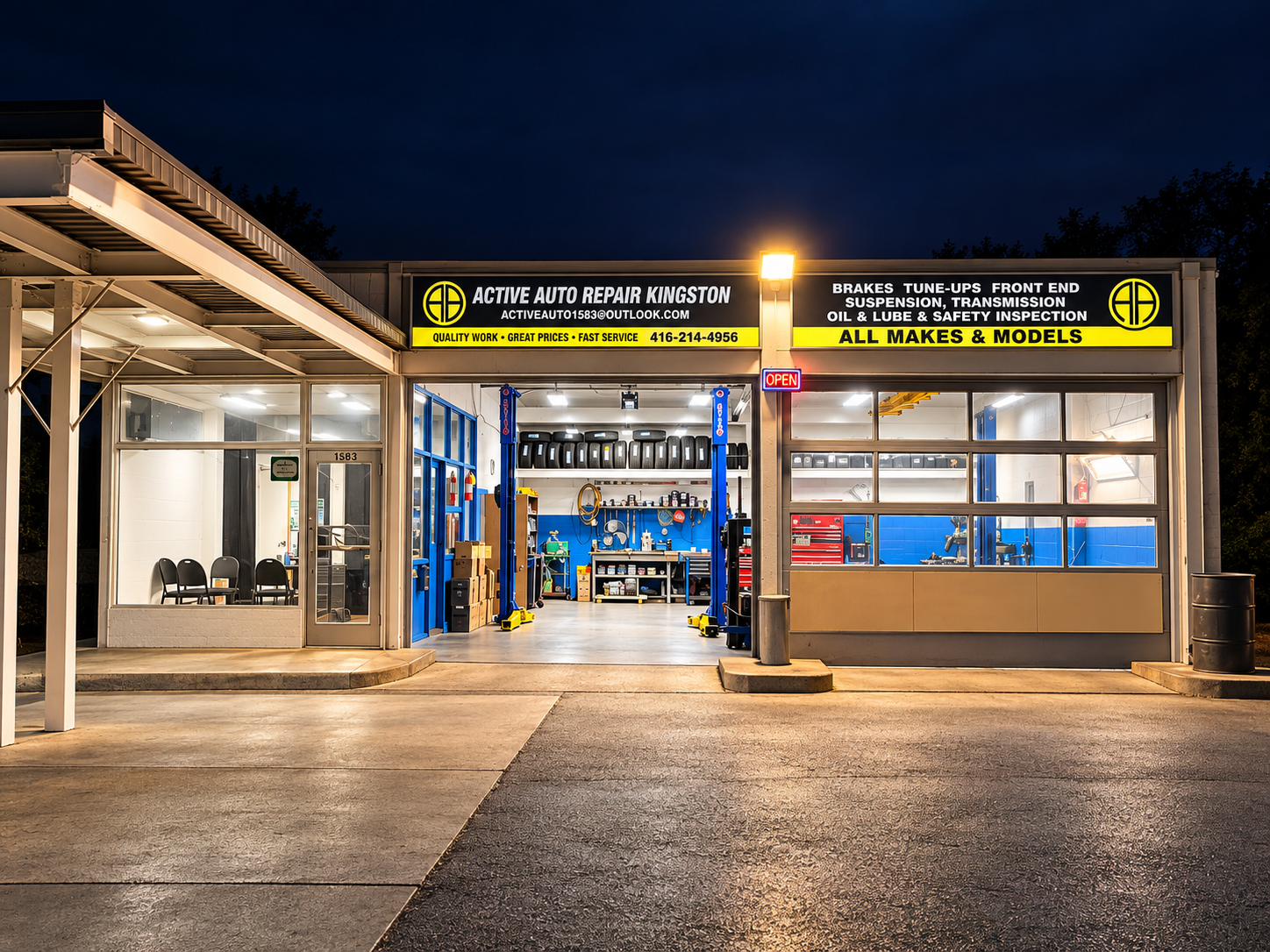 Active Auto Repair Kingston at night with the bay doors open and the lifts lit