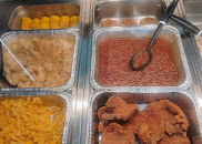 The hot case at Dino Food Mart with fried chicken, mac and cheese, corn and baked beans