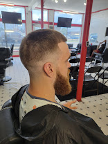 Client with a skin fade and full beard, seen from the side in the Boss Kutz chair